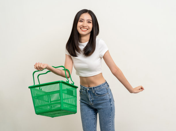 快乐的美女拿着购物篮。肖像美丽的亚洲女性在时尚风格站姿孤立的背景。年轻的亚洲女性在网上市场购物图片下载