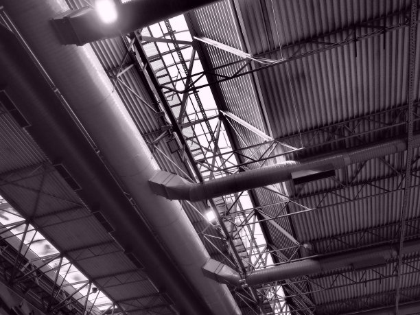机库、生产车间或体育馆的屋顶金属结构、梁、支撑元件。大厅和房间的通风系统。天窗。工业内部。图片下载