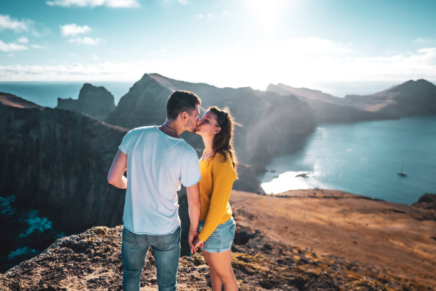 清晨，一对游客夫妇在大西洋马德拉岛的海岸风光上接吻。欧洲葡萄牙马德拉岛的<s:1> o loureno。图片下载