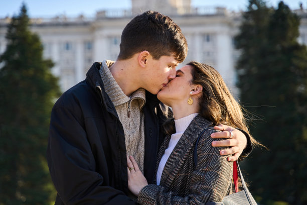 一对年轻情侣在城市街道上接吻的特写照片。图片下载