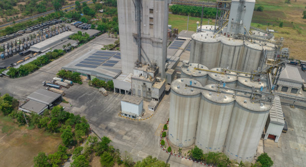 动物饲料厂鸟瞰图。农业筒仓，粮食储存库筒仓，以及工业厂房屋顶上的太阳能电池板。工业景观。农业产业。可持续能源工厂。图片下载