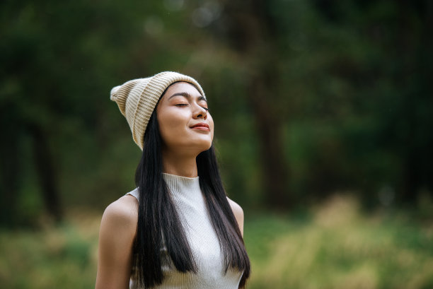 年轻漂亮的女人在森林里美丽的大自然中感到神清气爽图片下载