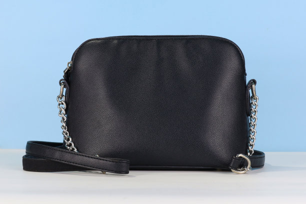 黑色女性皮包与肩带在蓝色背景图片下载