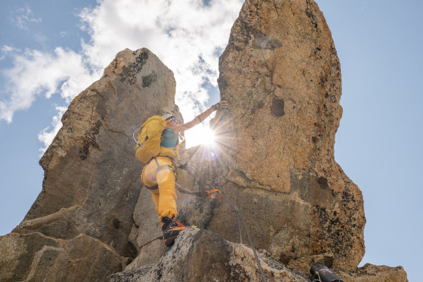 女性攀登山峰的低角度视图图片下载