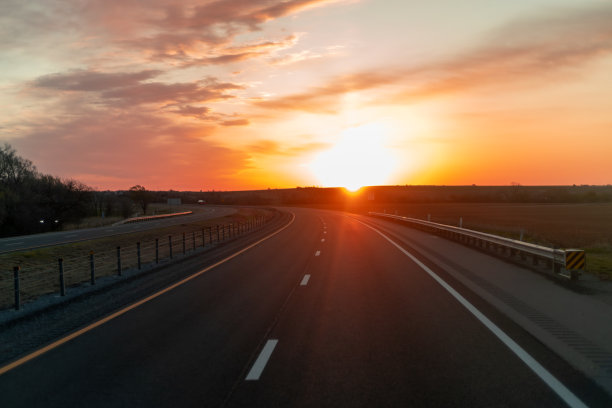 一条以日落为背景的高速公路。图片下载