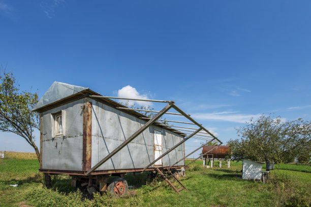 老式移动预制房屋安装在一个有水箱的田地里图片下载