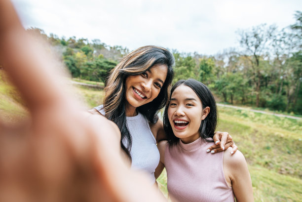 一群快乐的女性朋友用数码相机拍照图片下载