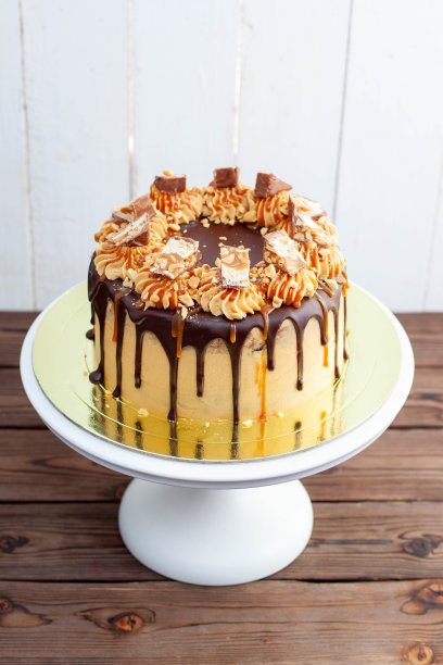 美味的士力架蛋糕，有花生酱奶油，融化的巧克力，糖果棒和咸焦糖图片下载