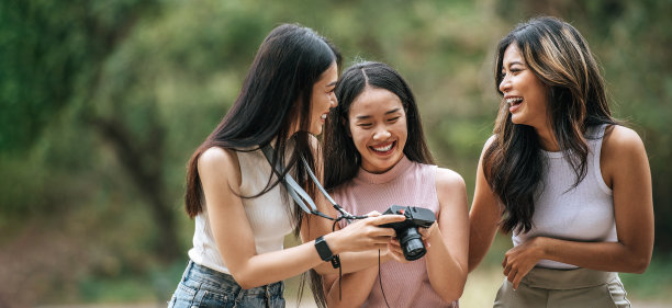 一群快乐的女性朋友在看数码相机上的照片图片下载