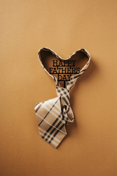 父亲节快乐的概念。棕色背景的心形领带。平躺，俯视图。图片下载
