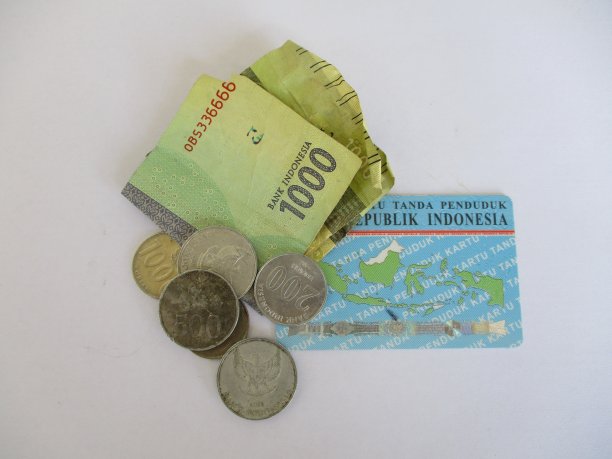 一千印尼盾硬币和纸币，带有印尼身份证，隔离在白底上。描述钱少或缺钱的图片下载