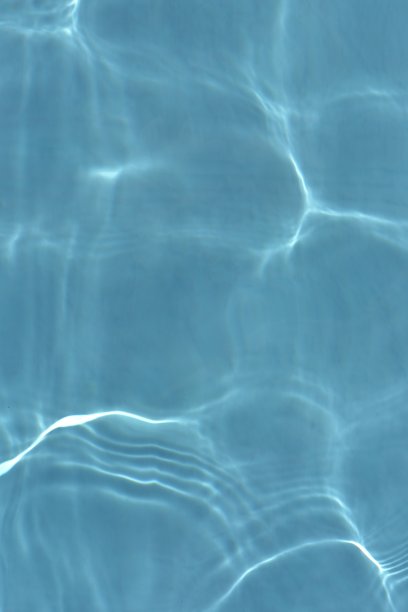 蓝蓝的水面上泛起涟漪。散焦模糊透明蓝色透明平静水面纹理与飞溅和气泡。水波与闪亮的图案纹理背景。图片下载