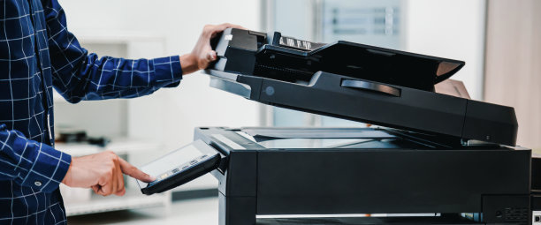 复印机打印机，近手办公人员按下面板上的复印按钮，使用复印机或复印机扫描文件打印一张纸。图片下载