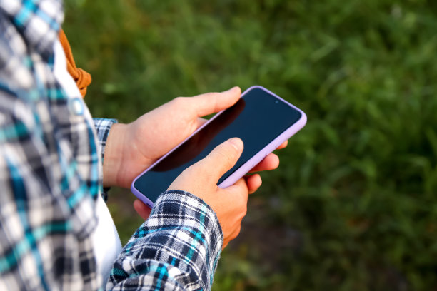 农民男性用手打电话。在户外场景中，一个特写镜头捕捉到了一个白人男性的手，牢牢地握着智能手机图片下载