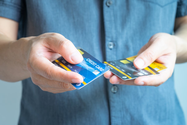 一名男子持有多张信用卡，他正在选择一张信用卡，通过信用卡支付和消费商品。金融和银行概念。图片下载