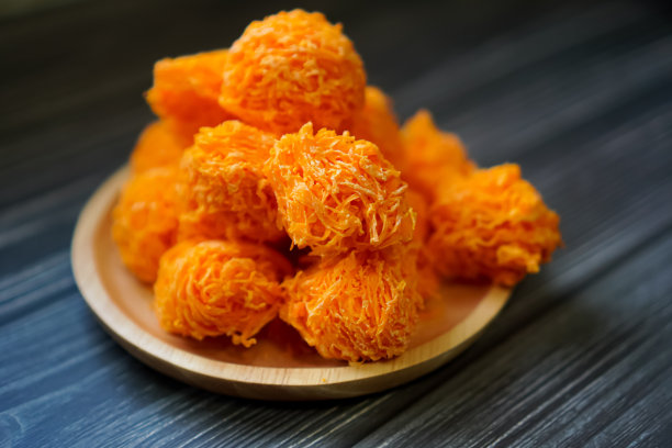 泰国甜品，厨房桌子上的木托盘上排列着脆皮金线甜点的特写。图片下载