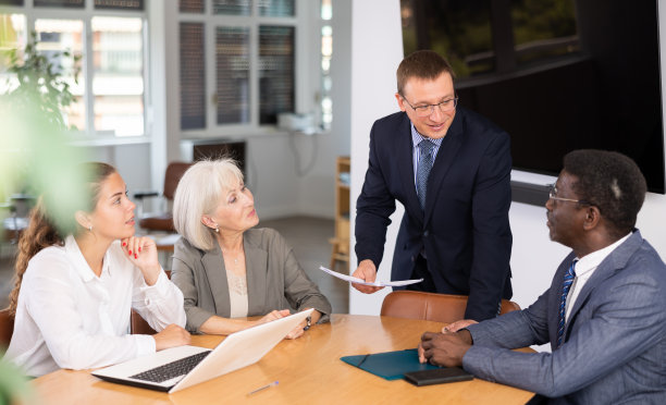 一群不同的人在办公室的桌子上讨论图片下载