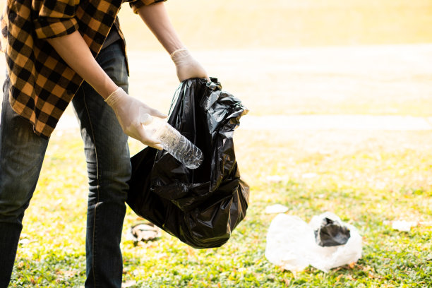 世界环境日，一只手捡垃圾的特写图片，展示了我们清洁和保护地球的决心。图片下载