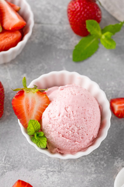 草莓冰淇淋和新鲜的浆果在一个灰色的混凝土背景碗。有选择性的重点图片下载