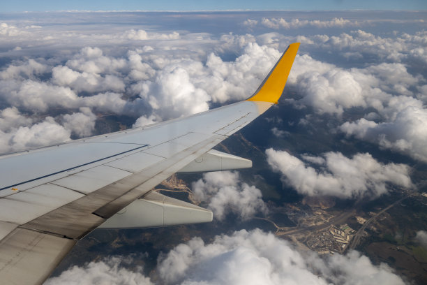 飞机的机翼在天空的云层上飞行图片下载