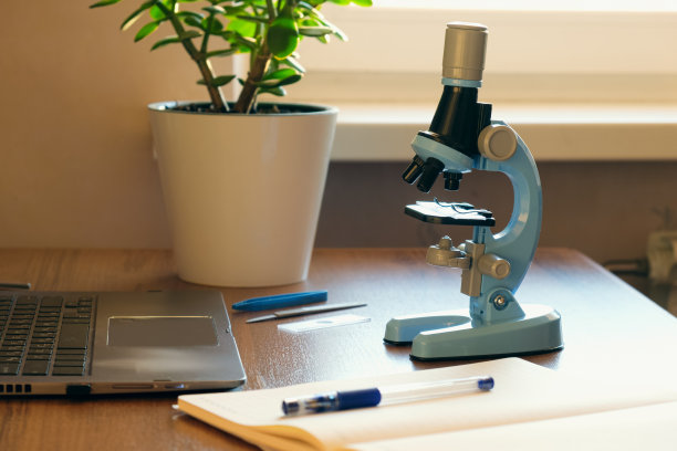 一个小学生拿着显微镜的工作场所。做化学或生物作业图片下载