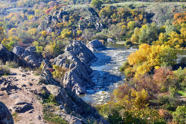 在一个阳光明媚的秋日，从山上看划艇运动员在白水河上划艇图片下载