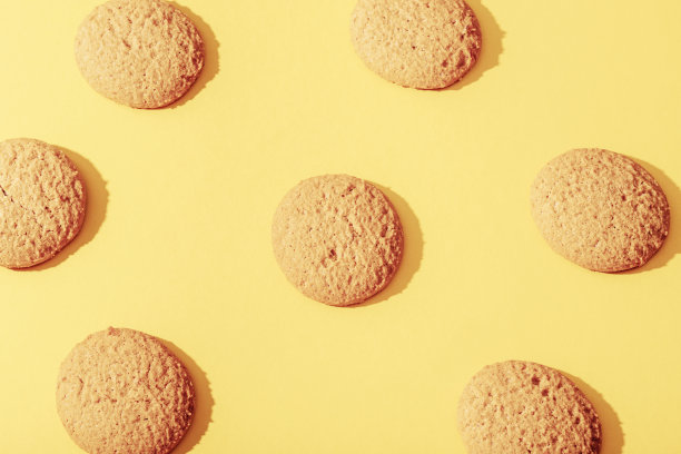 自制饼干在黄色背景与鲜明的阴影。俯视图，平铺图片下载