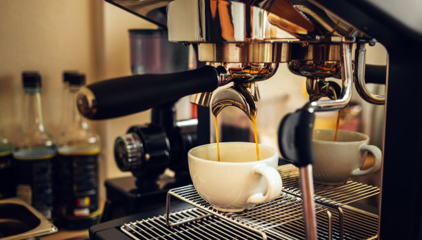 咖啡由专业咖啡师咖啡机萃取。咖啡店里从咖啡机里倒出来的浓缩咖啡。图片下载