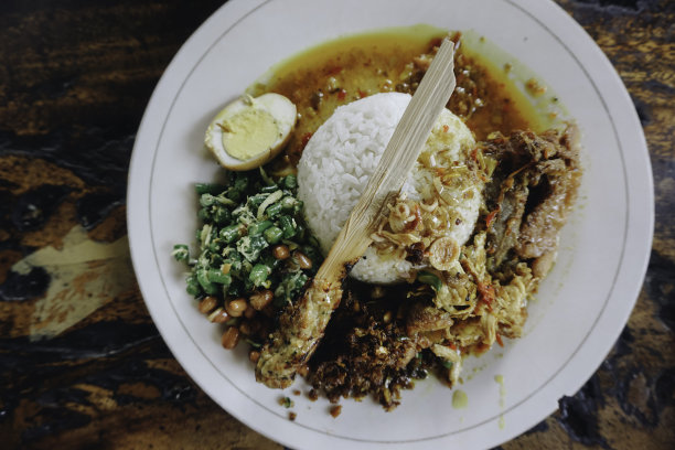 Nasi Campur Ayam Betutu用木薯叶填馅的巴厘岛烤鸡。配以蒸米饭，Sate Lilit, Jukut Antungan, Lawar Nangka和Sambal Matah。图片下载
