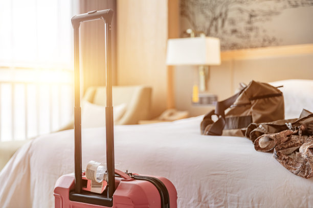 酒店房间有大床沙发和红色行李箱，客人刚刚入住图片下载