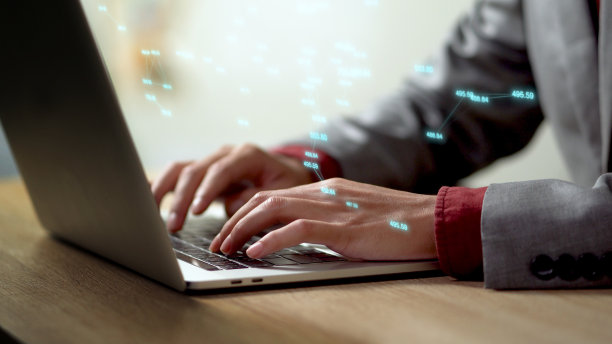 近距离商人的手忙于笔记本电脑或电脑键盘，HUD抬头显示数字和搜索数据。图片下载