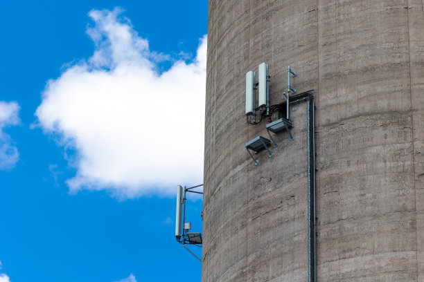 安装在高高的发电厂烟囱墙上的手机天线特写。图片下载