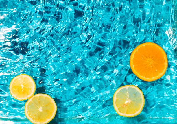 夏天的场景，橘子和柠檬水果在水中。阳光和阴影。最小的自然背景。图片下载