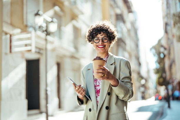 一个自信的女商人在城市里享受咖啡休息的肖像。图片下载