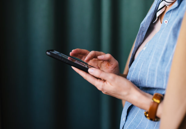 在咖啡馆里用手机的女人的手的特写照片图片下载
