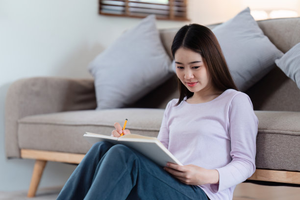 在线教育，电子学习。穿着时尚休闲服装的亚洲女性，用笔记本电脑学习，听在线课程，记笔记，在家在线学习图片下载