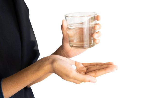 女人拿着药和一杯水图片下载