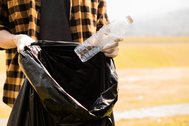 世界环境日，一只手捡垃圾的特写图片，展示了我们清洁和保护地球的决心。图片下载