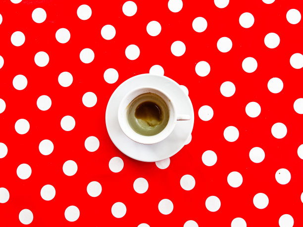一杯咖啡在红色圆点背景，俯视图图片下载