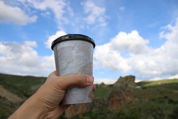 一杯咖啡或茶在男人的手中。在自然界中摄入液体图片下载