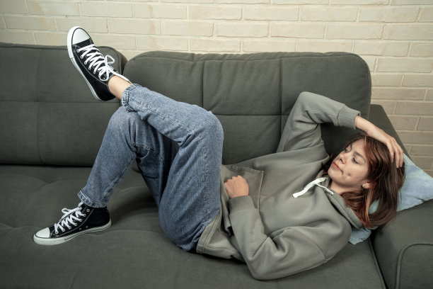 一个快乐放松的高加索女孩躺在舒适的沙发上休息图片下载