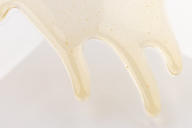 蜂蜜流。黄色的糖浆滴下来。天然产品和甜饮料。孤立在白色背景。图片下载