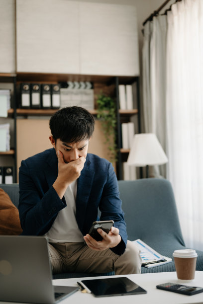 失意的年轻商人坐在家里办公的地方用笔记本电脑工作图片下载