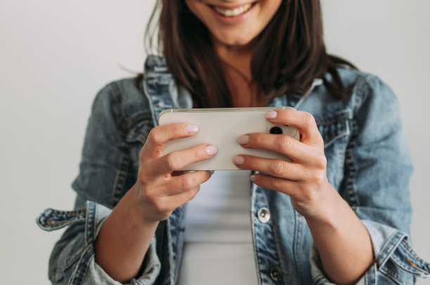 兴高采烈的女人看着她的智能手机图片下载