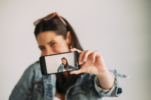 美女用智能手机拍照的特写，自拍。图片下载