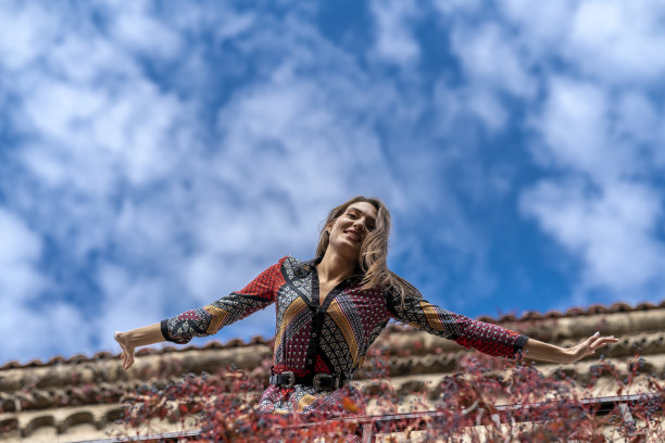 迷人的女人在秋天的背景下摆姿势拍照。图片下载