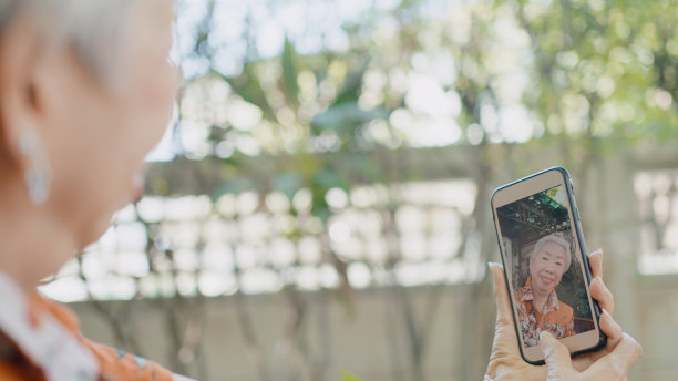 亚洲老年女性用手机自拍家中盆栽，健康生活方式，简单生活图片下载