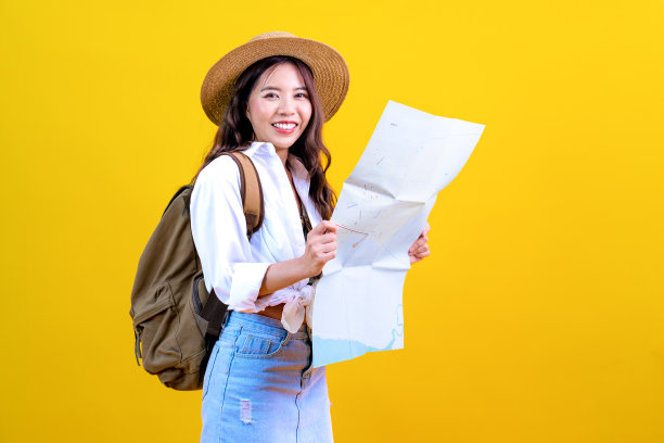 年轻的亚洲美女游客背着背包，带着地图探索新的城市图片下载