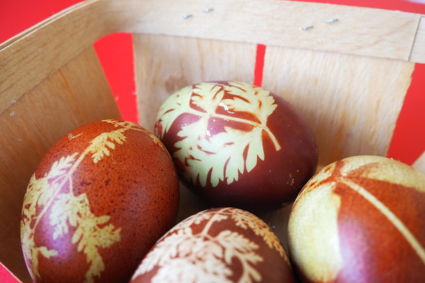 复活节篮子特写，里面有五颜六色的彩蛋。煮鸡蛋，有红色和棕色的壳，按照传统的食谱用洋葱皮染色。用植物叶子做成的花卉图案。图片下载