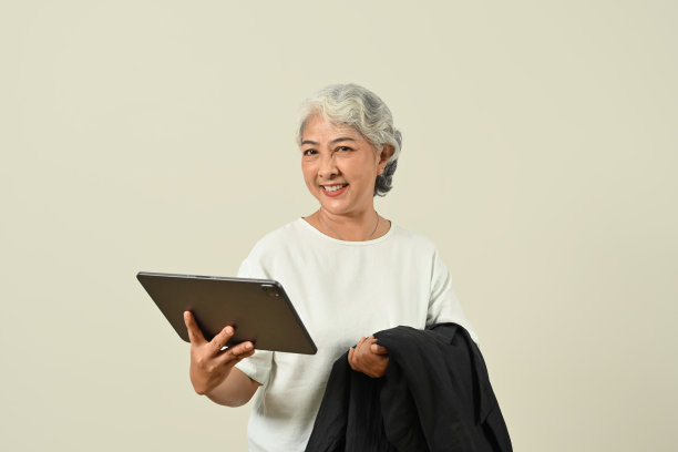 现代白发女子手持数码平板电脑，孤立地站在白色背景上。图片下载